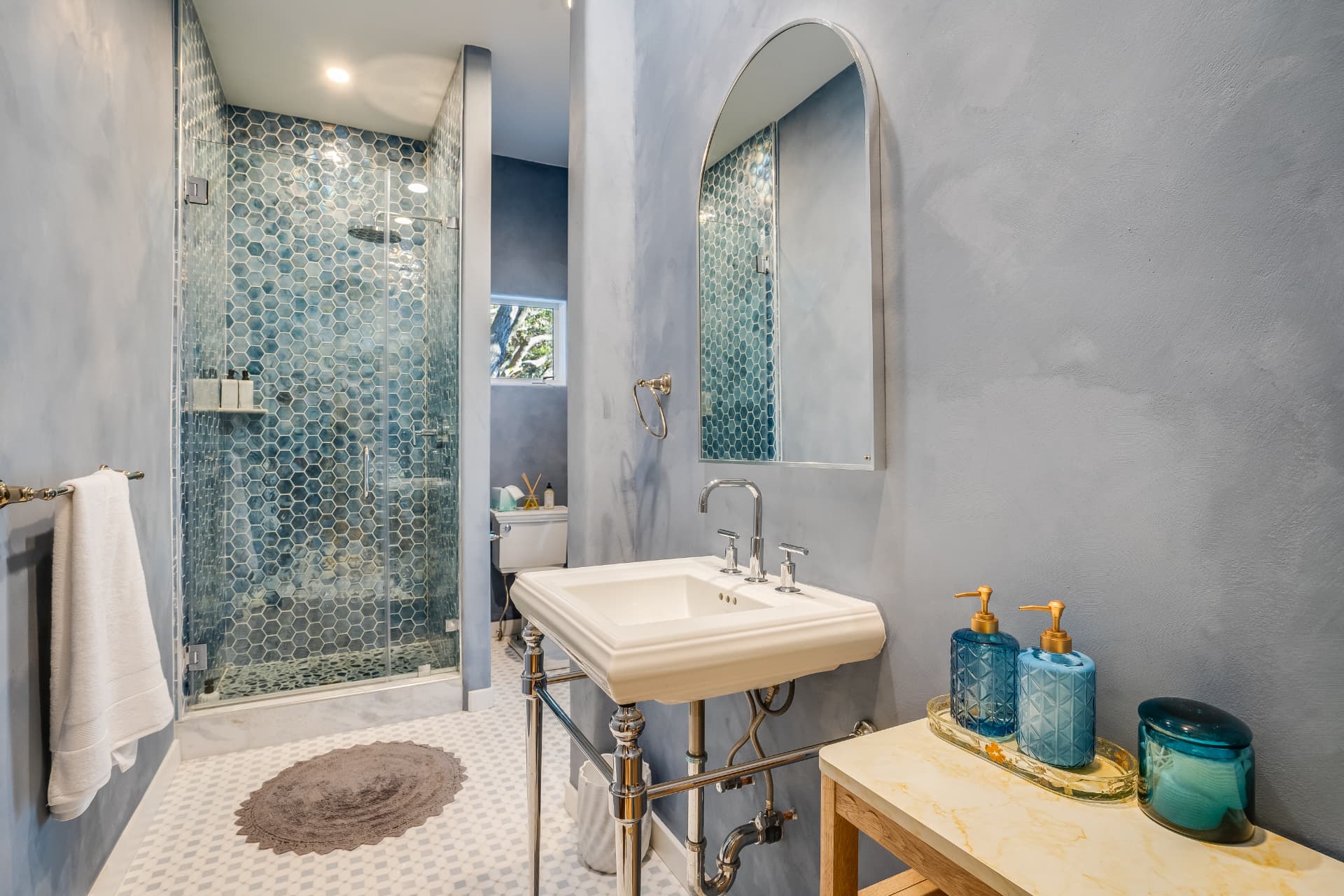 Primary bathroom remodel with a white oak double vanity, quartz top, and tiled soaking tub surround in Los Angeles